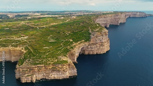 Drone view of cliffs on Gozo island, part of Malta island. Green fields, rocks and cliffs, caves. Mediterranean sea