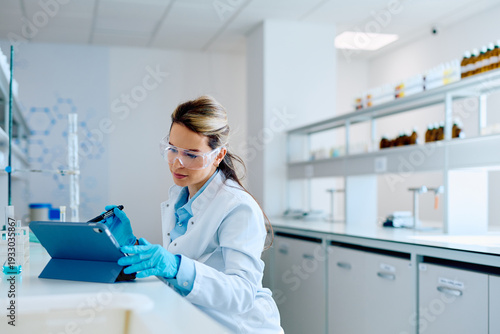 Принти на полотні Young female scientist wearing protective glasses and gloves, working with a dig