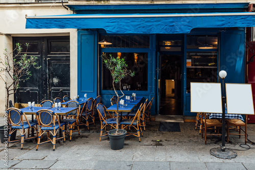 Typical view of the Parisian street with tables with tables of cafe in Paris, France. Architecture and landmark of Paris. Cozy Paris cityscape
