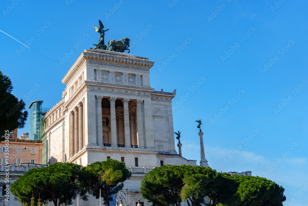 Fototapeta premium Historic building at a sunny day in Rome near green trees and blue sky