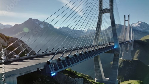 A sleek, modern suspension bridge stretches across a vast, mountainous landscape under a clear blue sky with wispy clouds