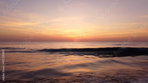 Beautiful Sunset Over the Ocean Waves with Golden Hues.