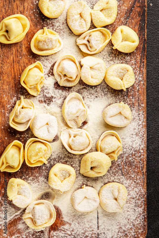 Fototapeta premium Raw ravioli pasta cooking flour and dough on the table tasty snack fresh delicious gourmet food background on the table rustic food top view copy space