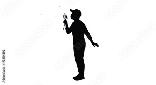 A man blowing dandelion seeds into the air striking black silhouette