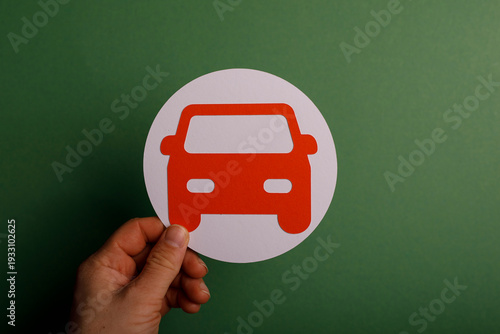 Hand holding a red car symb...