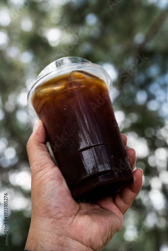 Wallpaper Mural Hand holding iced black coffee or americano coffee Torontodigital.ca