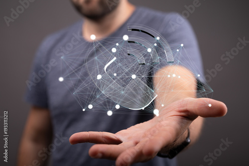 A man's hand holds a digita...