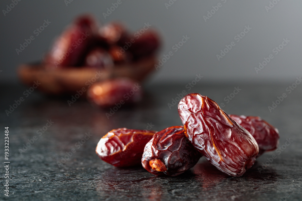 Obraz premium Dried dates fruit on a black table.