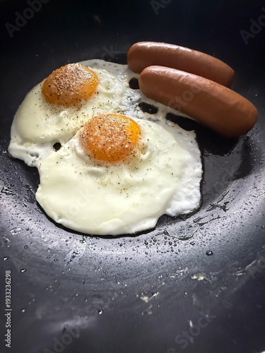 Healthy breakfast with frying eggs and sausages