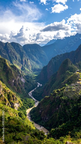 Mountain valley with winding river, lush greenery, and bright sky