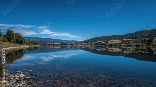 Wide Lake With Clear Water Under Blue Sky and Distant Hills Reflecting on the Water in a Natural Landscape