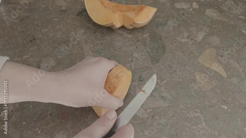 Female hands peeling pumpkin with knife