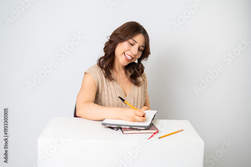 Mujer escribiendo en libreta (sonriendo)
