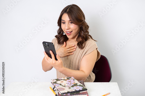 Mujer sorprendida mirando su celular con expresión de emoción