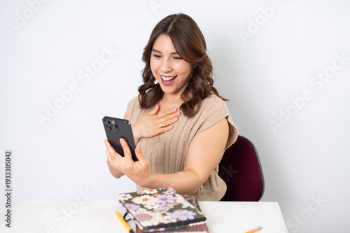Mujer sorprendida mirando su celular con expresión de emoción