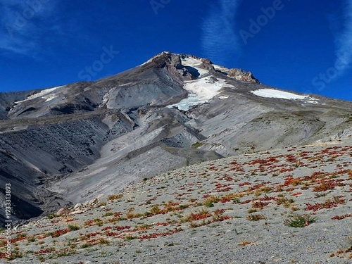 Majestic mountain peak with melting snow and sparse spring vegetation
