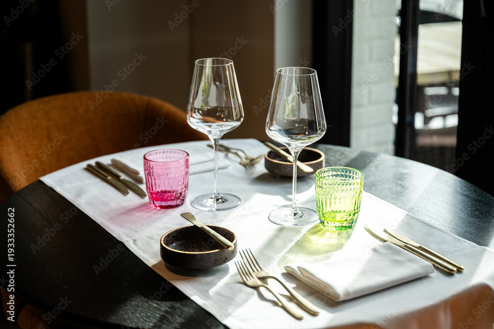 Fototapeta premium Sophisticated table with colorful glassware. Upscale restaurant decor with elegant table settings