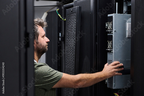 Fotografie IT technician installing server hardware in a data center rack performing mainte