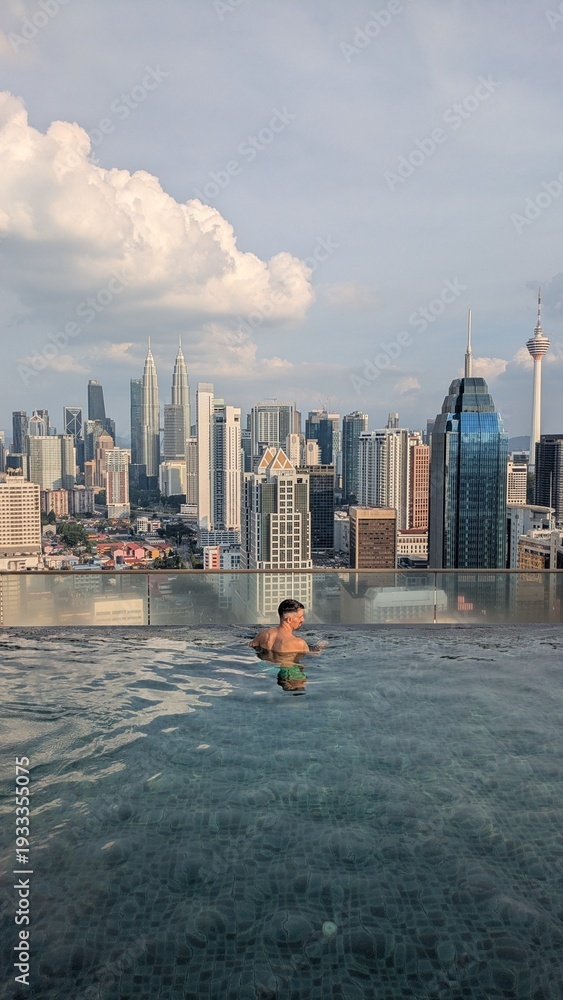 Fototapeta premium Serene luxurious rooftop pool escape in metropolitan Singapore Kuala Lumpur metropolis, man enjoying stunning skyline panoramic view of skyscraper city center urban architecture in Asia