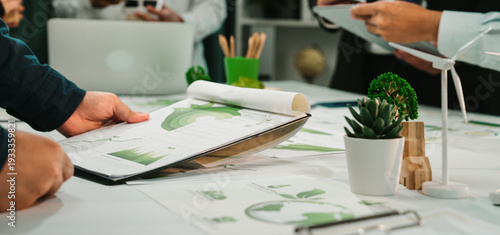 фотографія Engaging scene of a business meeting focusing on financial reports and sustainability strategies, showcasing teamwork and collaboration in a modern workspace