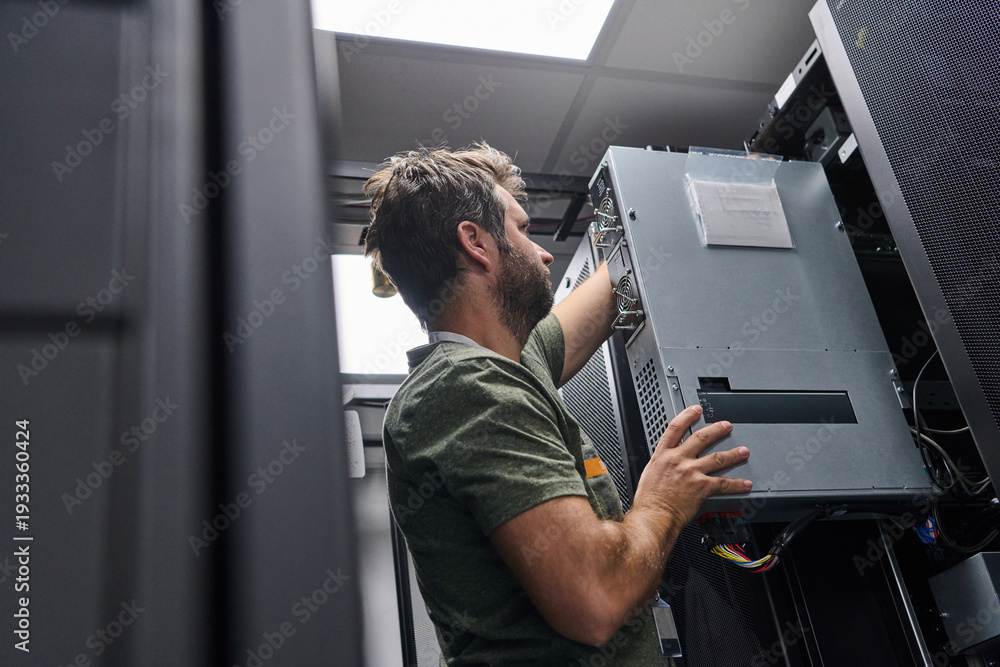 Obraz premium IT technician installing server hardware in a data center rack performing maintenance and network setup