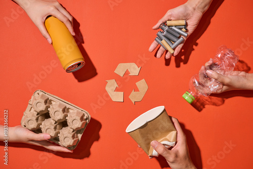 Hands demonstrate recycling by holding various recyclable items