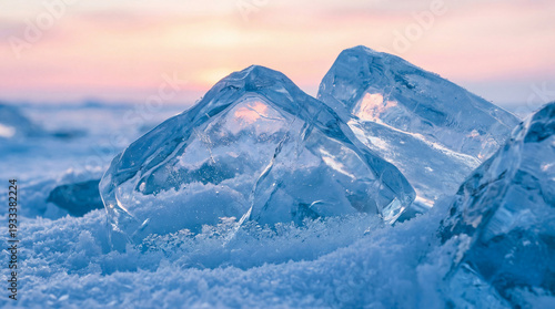 Ice chunks on snowy ground with soft pastel colors at sunset  
