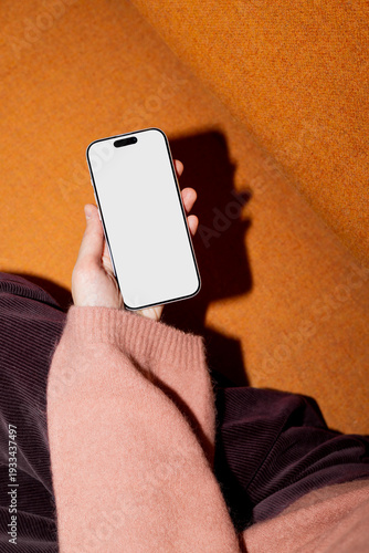 Business smartphone mockup held by hand against orange background