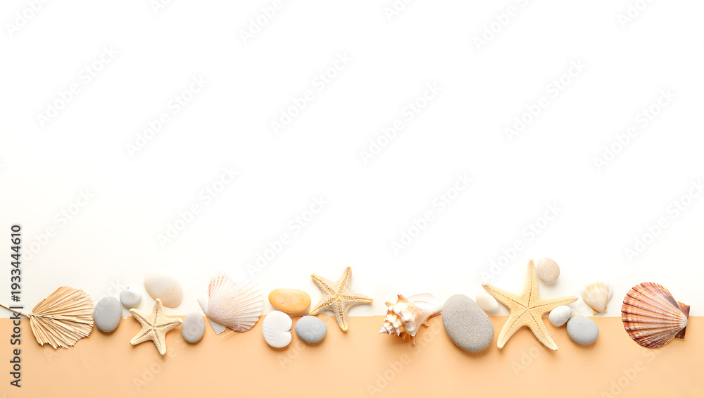 Obraz premium Assorted seashells and smooth pebbles creating a natural border.