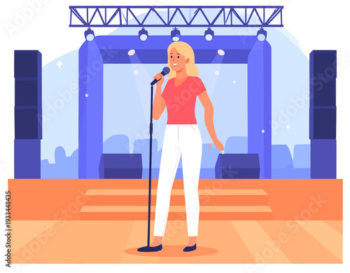 A blonde woman singing into a microphone on a brightly lit stage with large speakers and a backdrop.