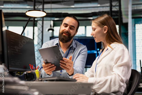 Canvas Print Lead technician providing support to new employee in software development agency using tablet