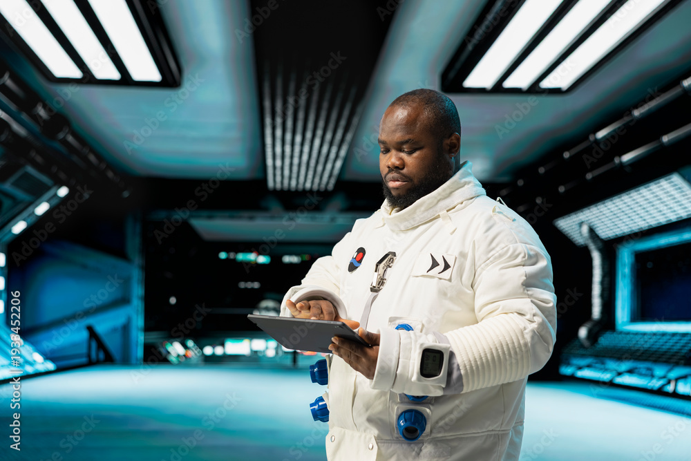 Fototapeta premium Cosmonaut in starship navigating orbital trajectory using tablet, doing galaxy expedition for future of mankind. African american astronaut mapping unknown worlds, exploring planets