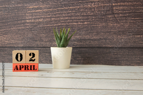 2 April on wooden grey cubes. Calendar cube date 02 April.