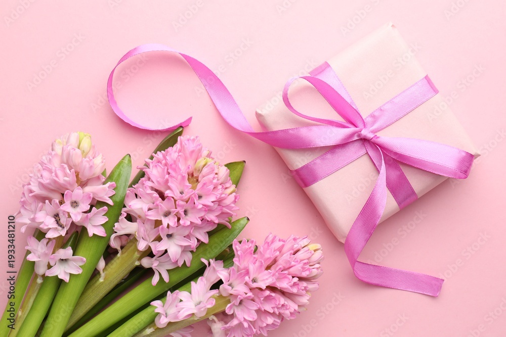 Fototapeta premium Beautiful hyacinth flowers and gift box on pink background, flat lay