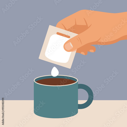 Hand holding tea bag over a cup of hot beverage