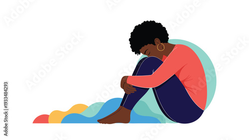 Depressed Black woman sits on the floor in a fetal position hugging her knees with a colorful abstract wave pattern behind her back.