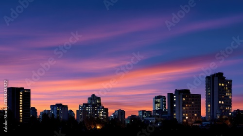 Vibrant Sunset Over City Skyline with Colorful Clouds and Building Lights Illuminating the Urban Landscape at Dusk