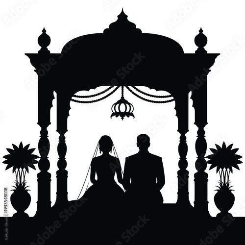 Silhouette of a wedding couple seated beneath an ornate mandap structure