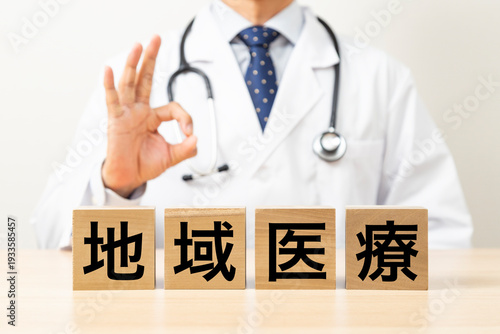「地域医療」と書かれたブロックとOKサインをする医師