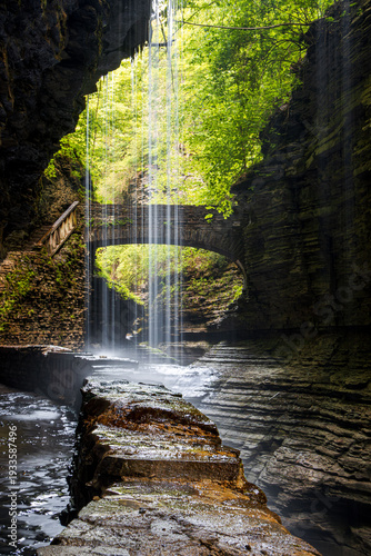 mesmerizing motion beautiful gorge waterfall with a path walk and bridge and curtain of water strings shielding the view