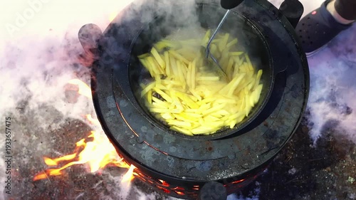 Pan full of hot food emitting steam in snowy landscape. Rustic cuisine concept and winter travel lifestyle. Metal stove top with steaming dish. Expedition cooking and cold climate atmosphere.