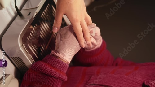 Vertical video. Hand manicure. Nail polish removal. Professional female manicurist in protective gloves emery board clients beauty care.