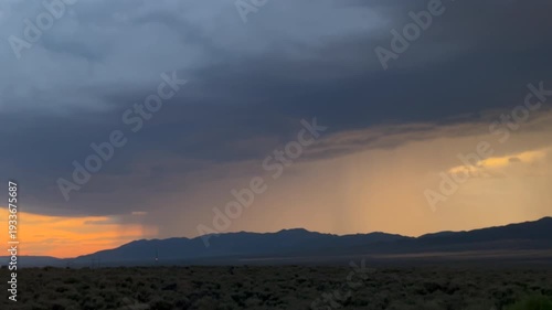 Heavy rainfall, thunder and lightning in the distance, at sunset in the summertime. Taken at a plain in the American West. 