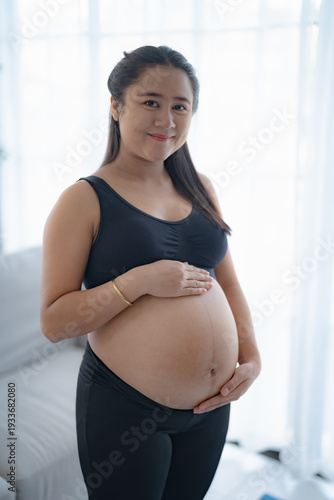 Pregnant asian woman holds hands on belly touching her baby caring about her health Beautiful happy pregnant woman tender mood photo of pregnancy. Free Download Pregnant asian woman holds hands on belly touching her baby caring about her health Beautiful happy pregnant woman tender mood photo of pregnancy. - GFXLoad