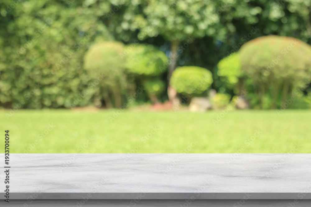 Fototapeta premium Empty marble table top with abstract blur green park garden background