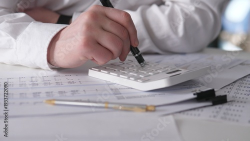 Focused Hands Entering Numbers On Calculator Amid Tax Forms And Receipts, Tense Filing Preparation With Pen And Stacked Documents, Deadlinedriven Accounting