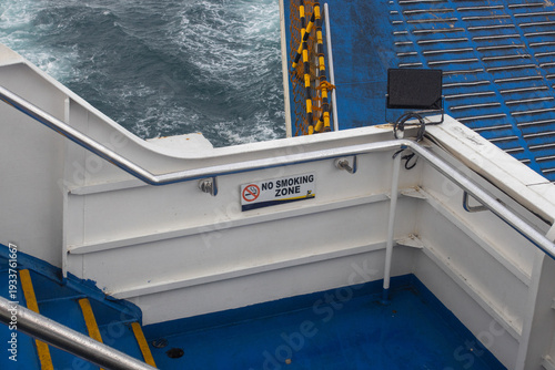 No Smoking Zone Sign on Ship Deck with Sea Waves and Ferry Infrastructure