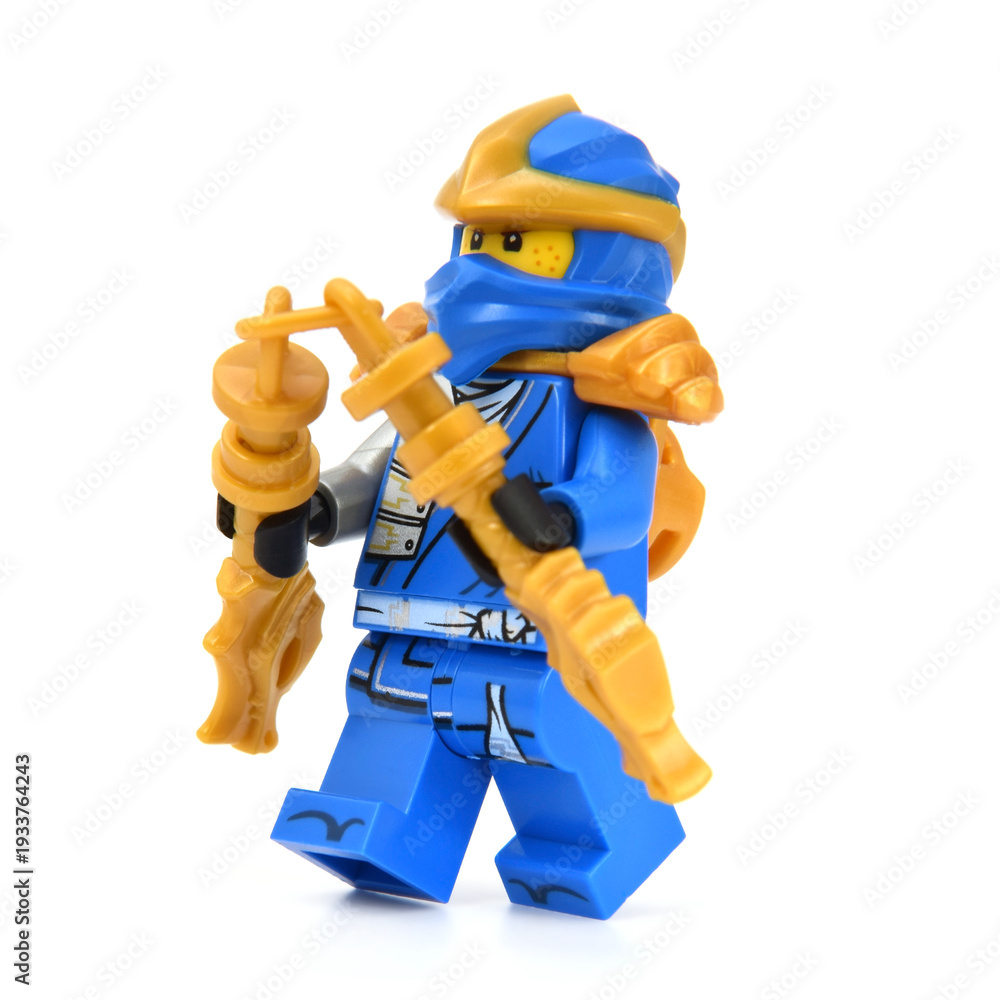 Fototapeta premium Editorial illustrative image of lego minifigure of blue ninja Jaywith golden blades weapon isolated on white. Jubilee 15 years of lego Ninjago.