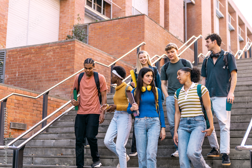 Obraz premium Diverse group of university students with backpacks and books walking down outdoor stairs, discussing and heading to class