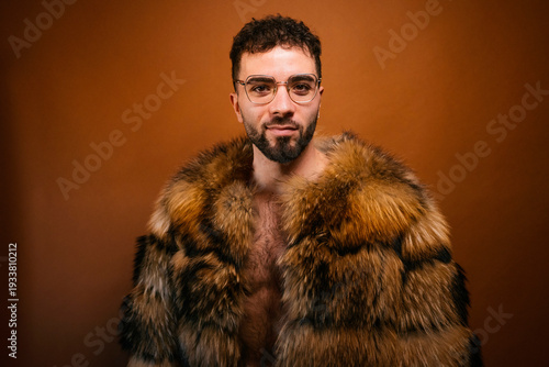 Confident man wearing stylish fur coat looking at camera